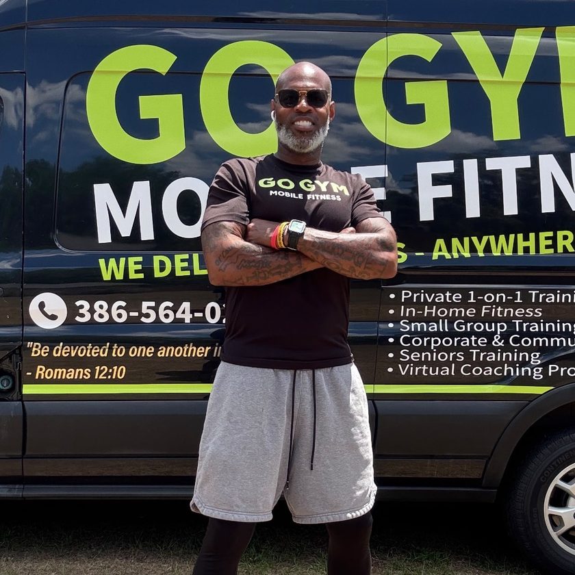 Jeramie &ldquo;Coach Jerry&rdquo; Irvin Sr. smiling with arms crossed in front of the GO GYM! Mobile Fitness van